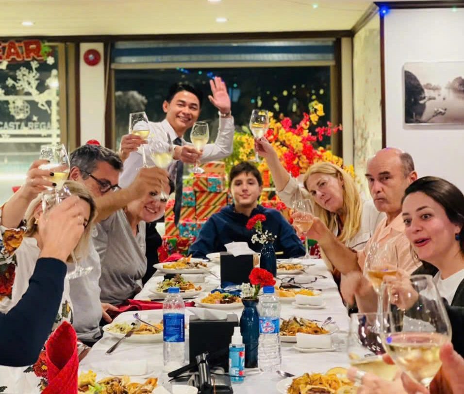 Guests enjoying a fine dining experience at La Casta Cruise restaurant with elegant interior and panoramic views of Halong Bay.