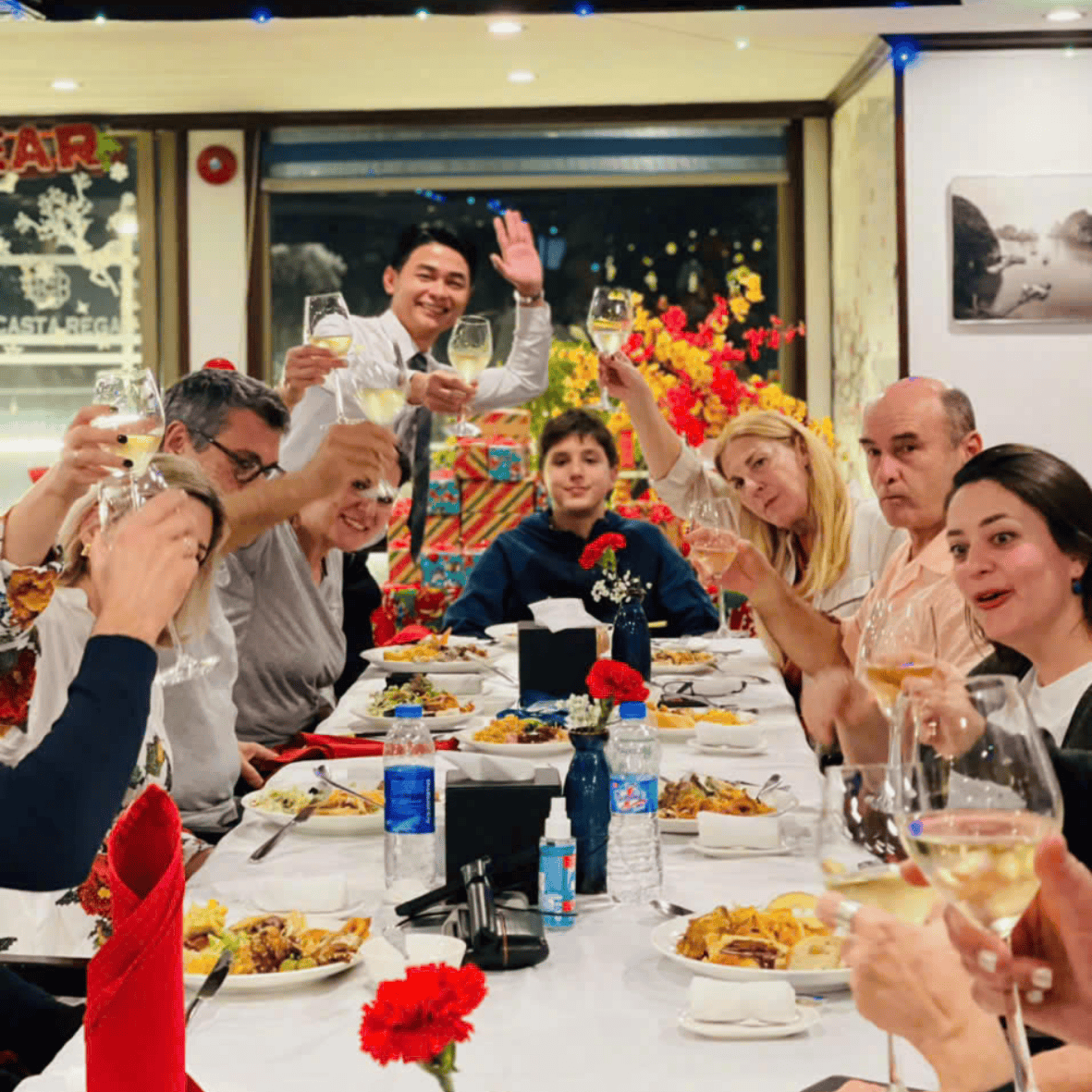 Guests enjoying a fine dining experience at La Casta Cruise restaurant with elegant interior and panoramic views of Halong Bay.